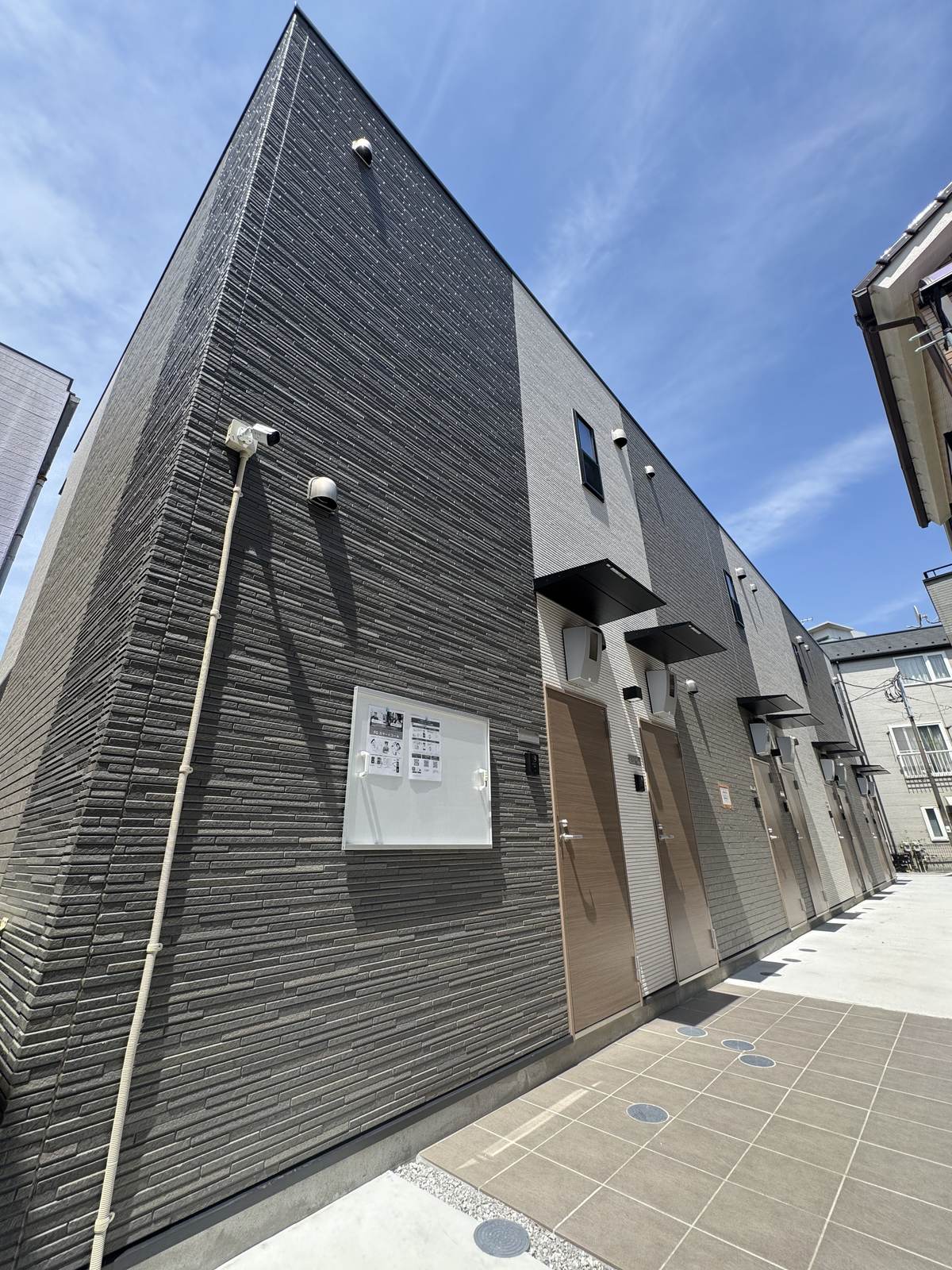 TS・二子の外観。縦ラインを強調した黒い外壁の建物