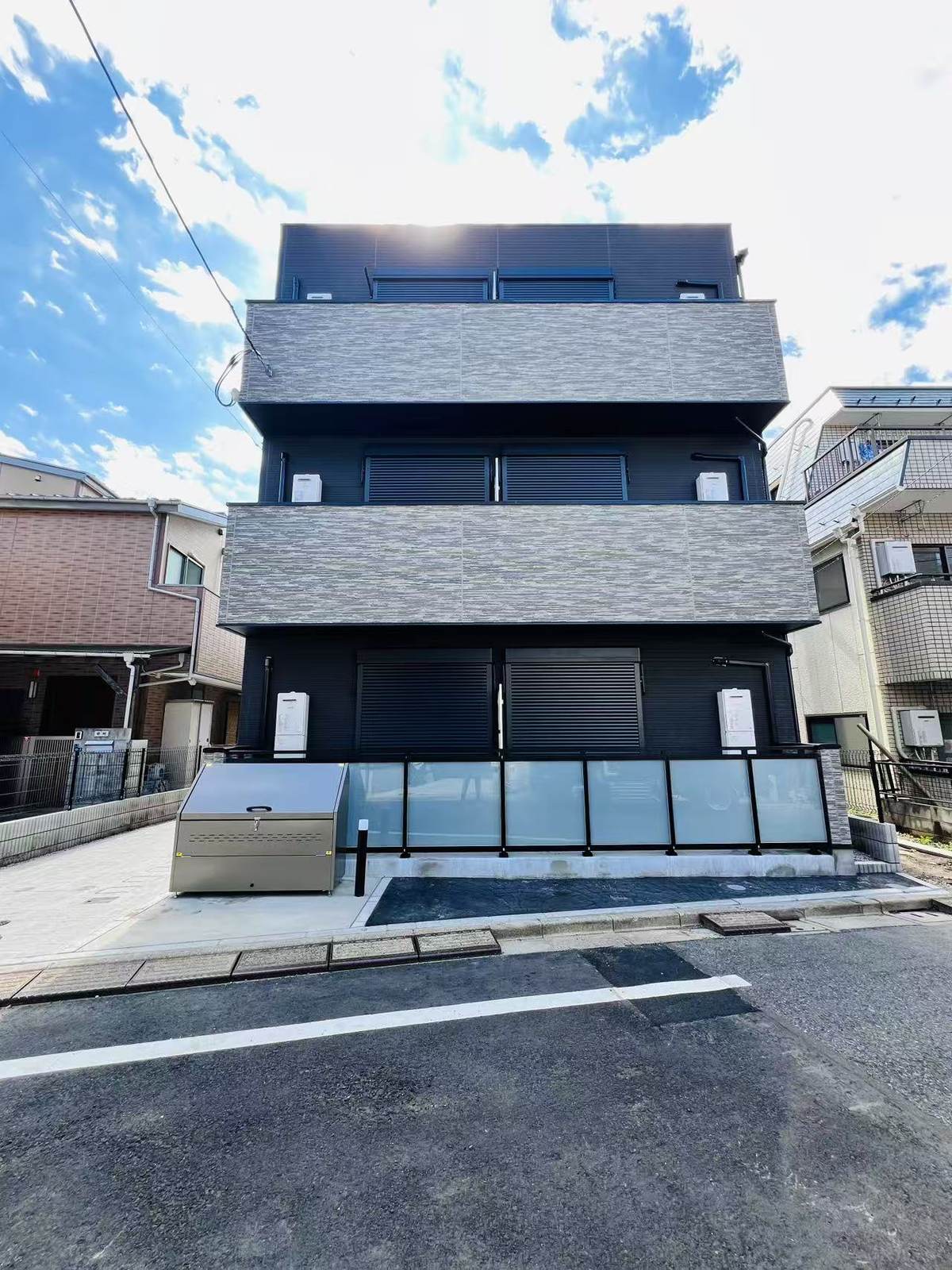 TS・志茂の外観。黒と石目調タイルを組み合わせた3階建て
